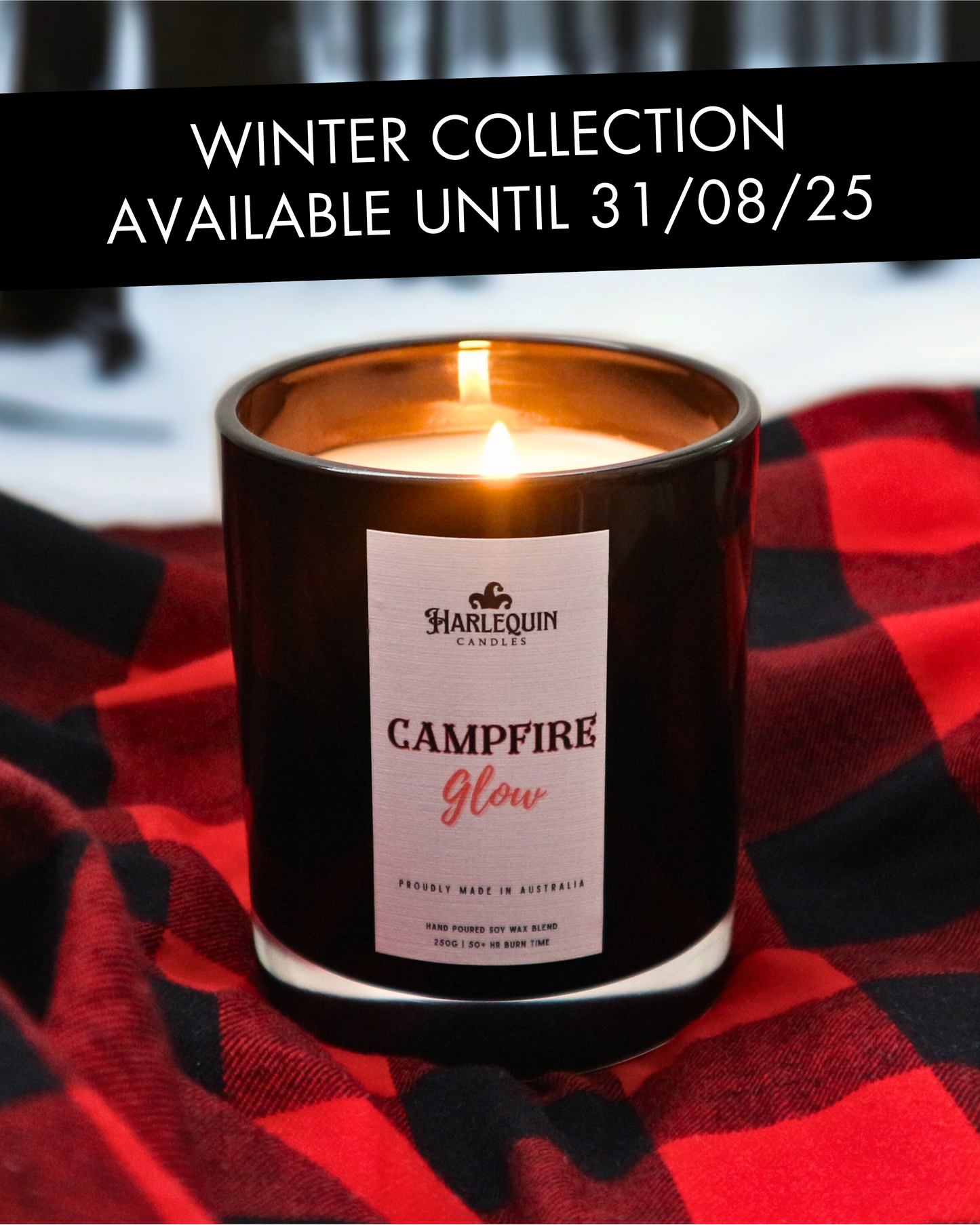 Harlequin Candles 'Campfire Glow' soy wax candle burning on a red and black plaid blanket, with a snowy Australian forest in the background. Creates a cozy, rustic wood smoke scent, ideal for Australian winter nights.