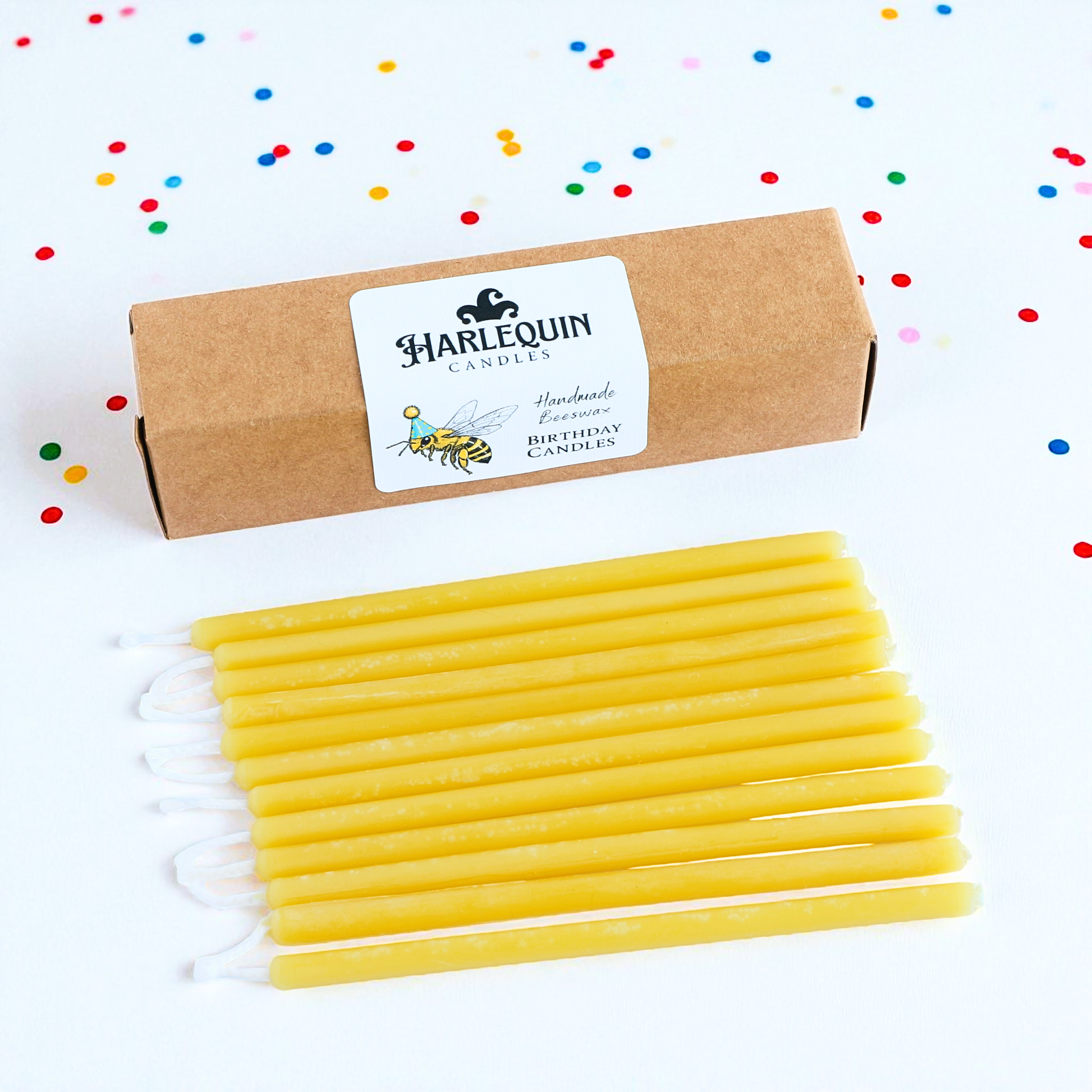 Harlequin Candles, yellow beeswax birthday candles on white background with confetti.