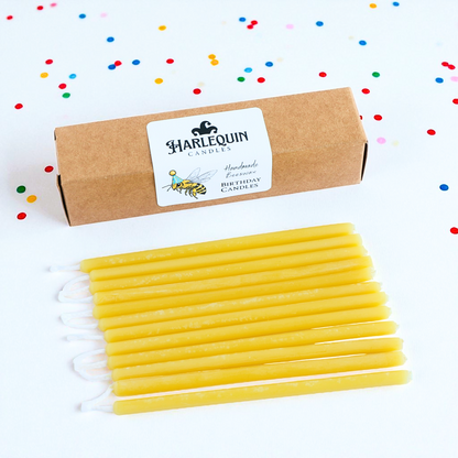 Harlequin Candles, yellow beeswax birthday candles on white background with confetti.
