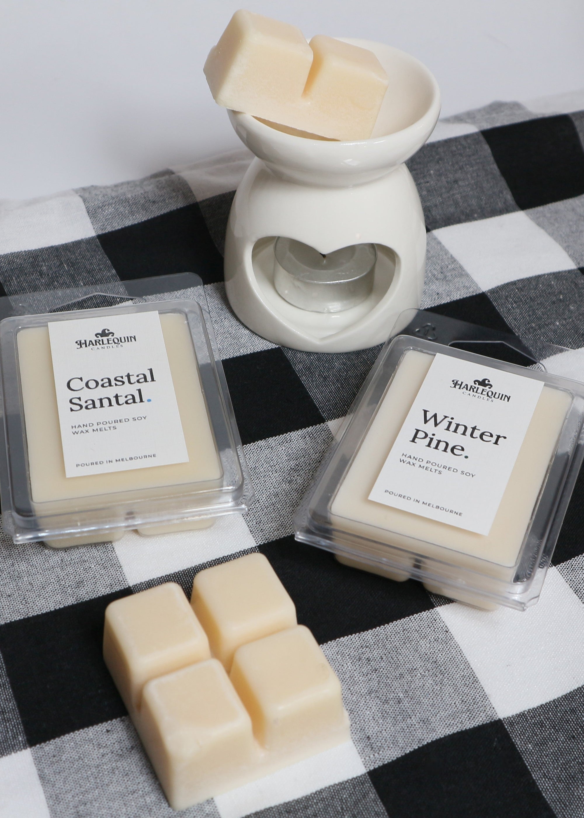 Hand-poured soy wax melts by Harlequin Candles displayed with a ceramic wax burner in a cosy home setting. Made in Melbourne for long-lasting home fragrance.
