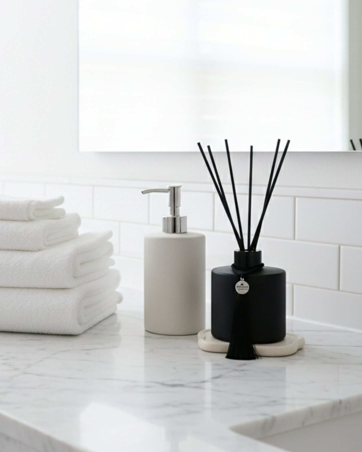 A black matte reed diffuser in a clean white bathroom, evoking a refreshing and comforting space.