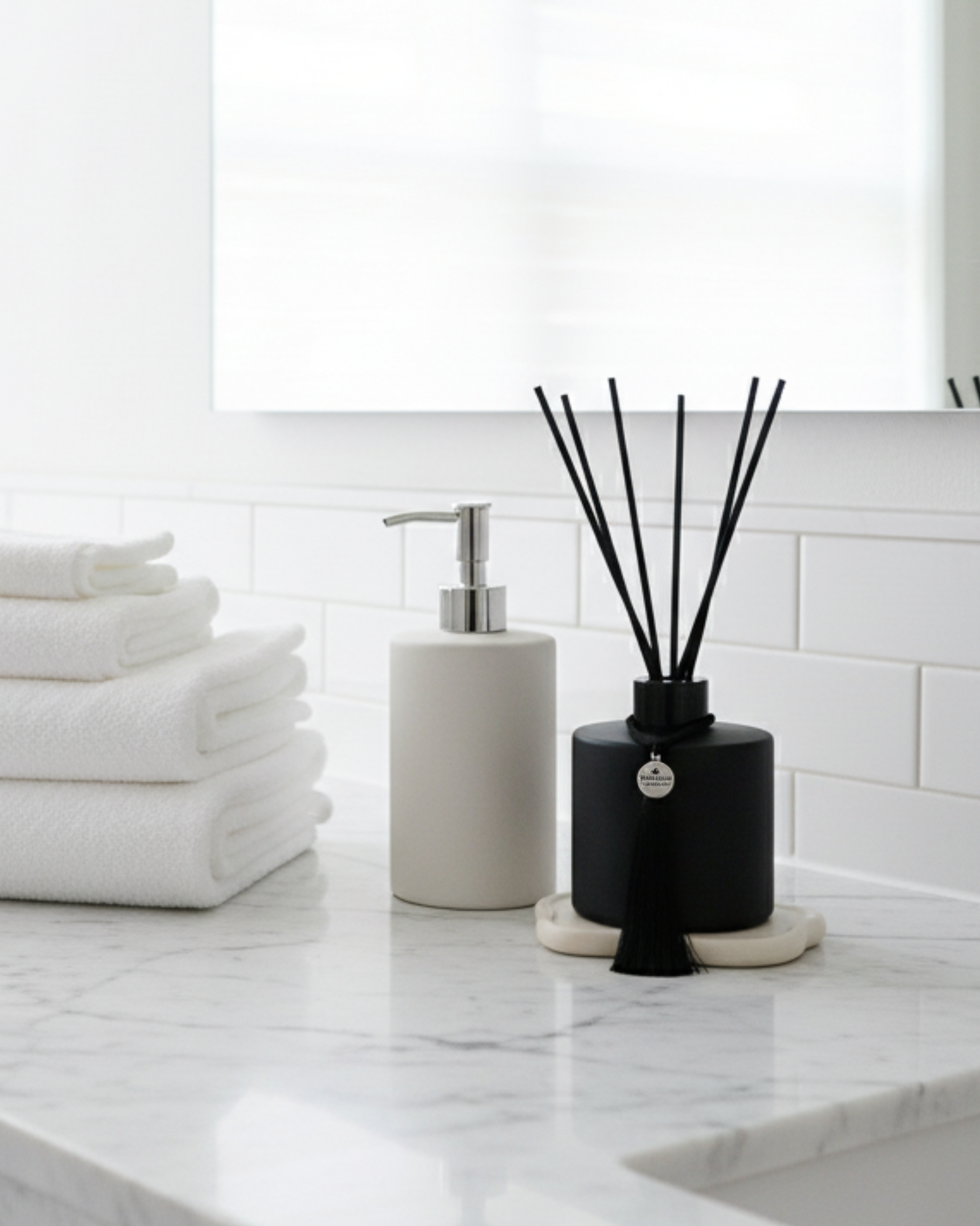 A black matte reed diffuser in a clean white bathroom, evoking a refreshing and comforting space.