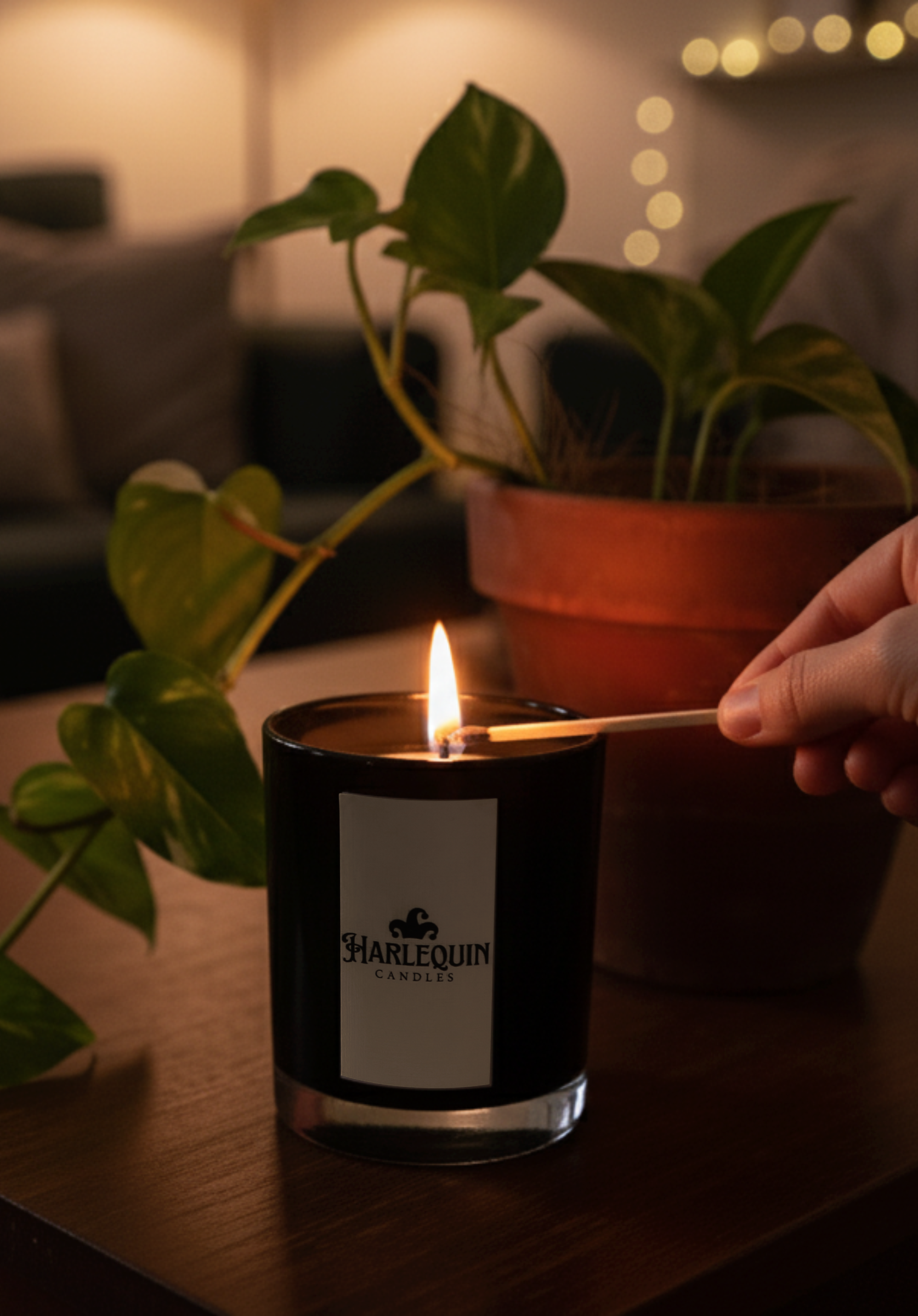Hand lighting a Harlequin Candles natural soy candle on a coffee table in a cozy living room. Perfect for home décor, relaxation, self-care, and hygge.
