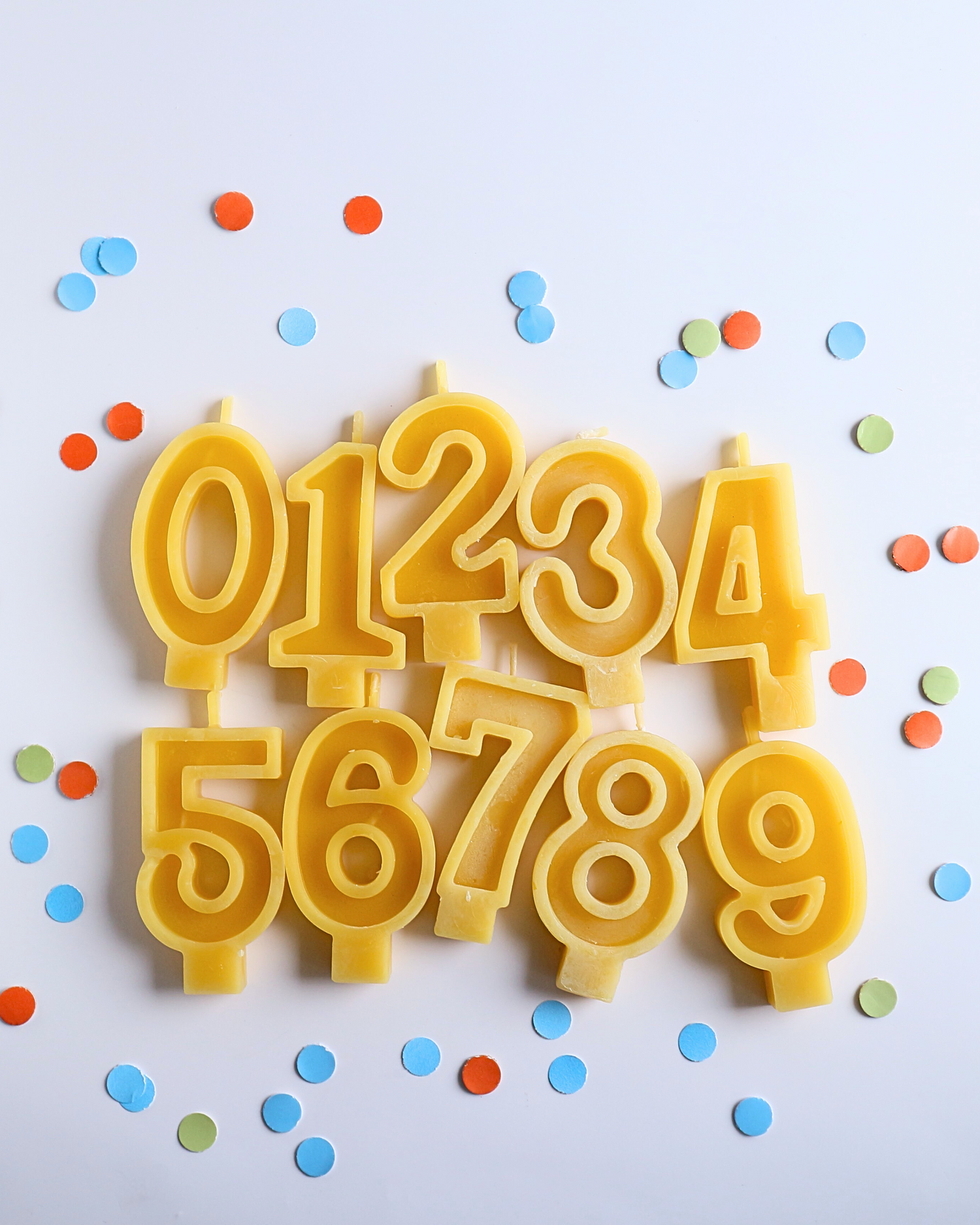 Yellow number beeswax birthday candles  on a white background.