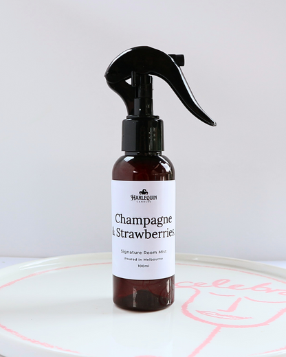 100ml amber bottle of Champagne and Strawberries signature room mist by Harlequin Candles, featuring a black trigger spray and minimalist white label.