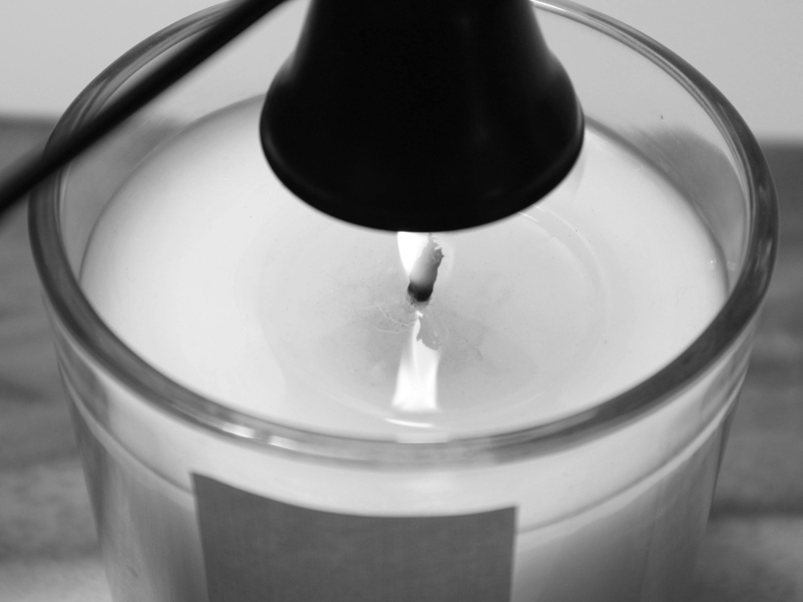 Close-up of a lit Harlequin candle made with soy wax, showcasing a bright flame in a clear glass jar. Premium Australian made candles.
