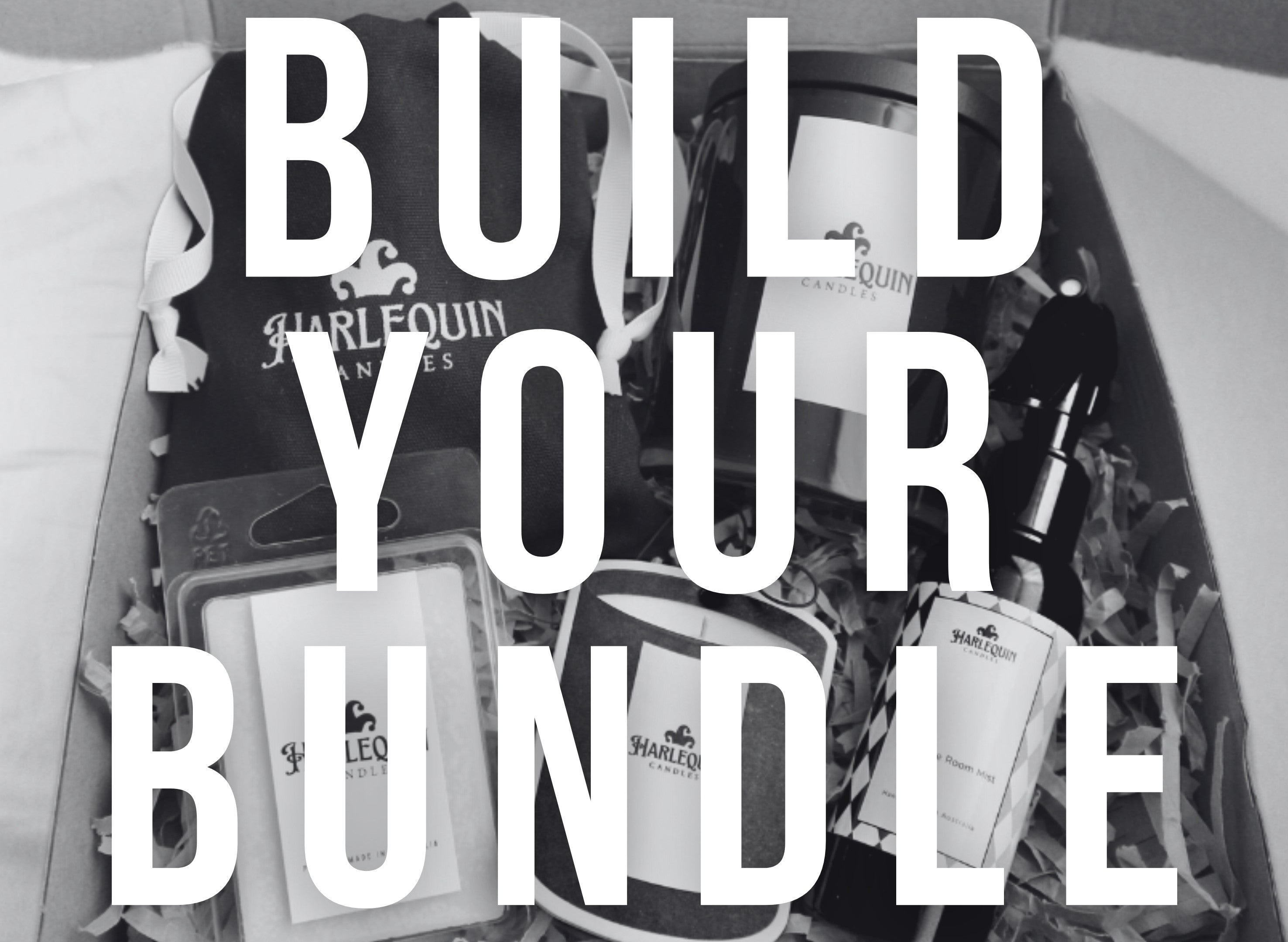 Monochrome banner with large 'BUILD YOUR BUNDLE' text. Below, an open gift box reveals various Harlequin Candles products including a soy candle, room mist, soy melts, nestled in shredded paper. Promotes customisable home fragrance gift sets.