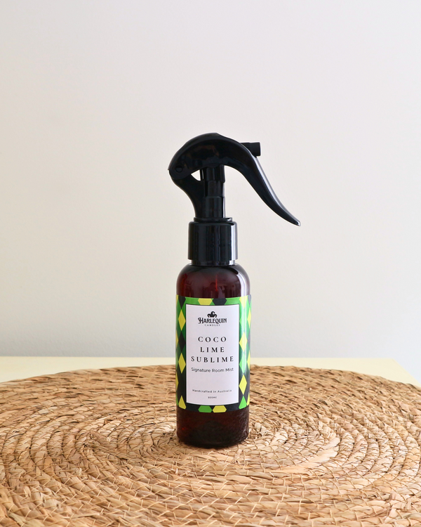 
Handcrafted Australian Coconut Lime  room mist by Harlequin Candles, presented in a luxe amber spray bottle on a textured woven mat against a soft neutral background.