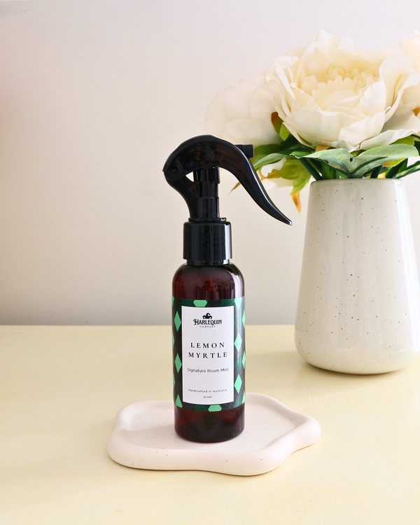 Handcrafted Australian Lemon Myrtle room mist by Harlequin Candles, presented in a luxe amber spray bottle against a soft neutral background.