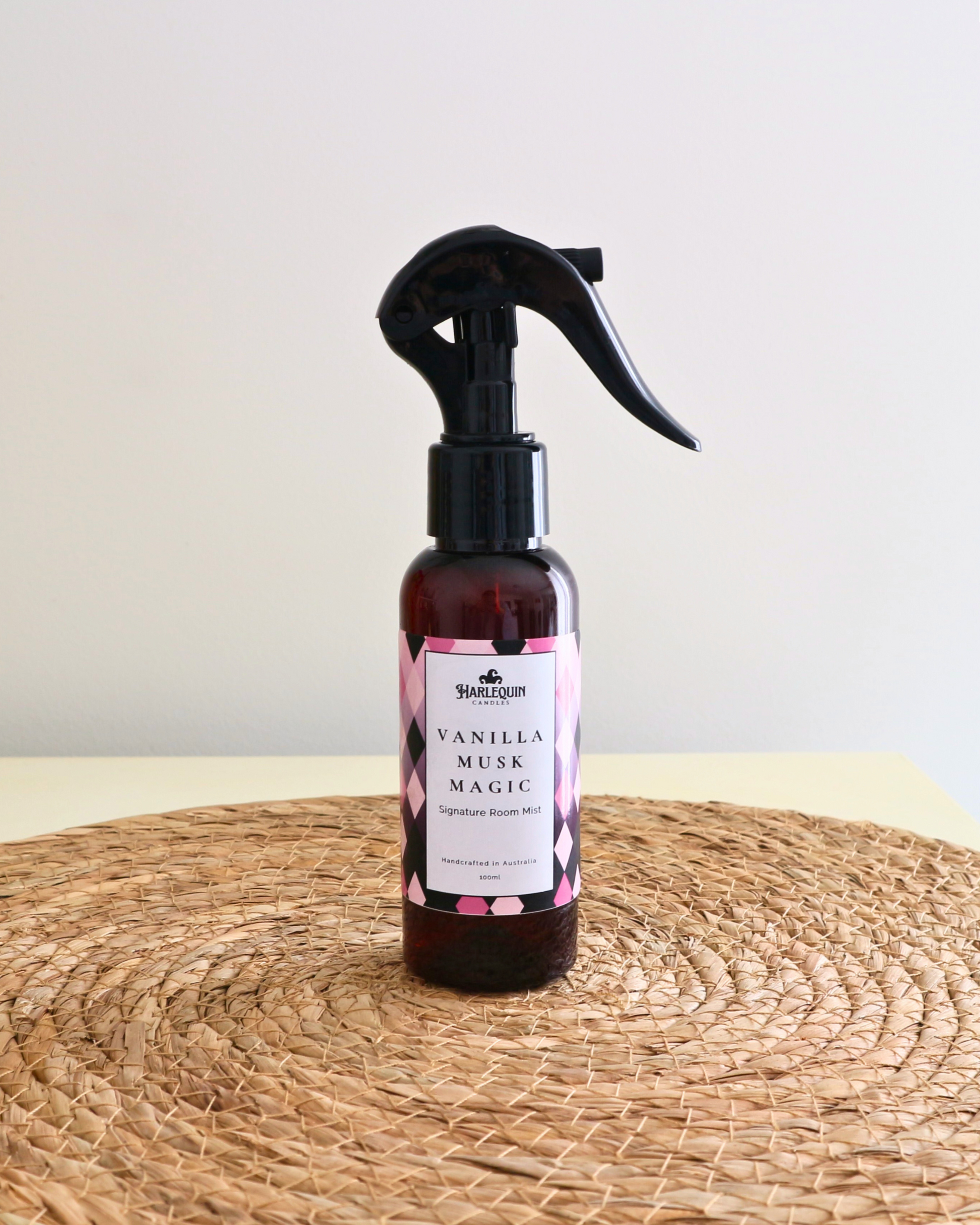 Handcrafted Australian Vanilla Musk Marshmallow room mist by Harlequin Candles, presented in a luxe amber spray bottle on a textured woven mat against a soft neutral background.