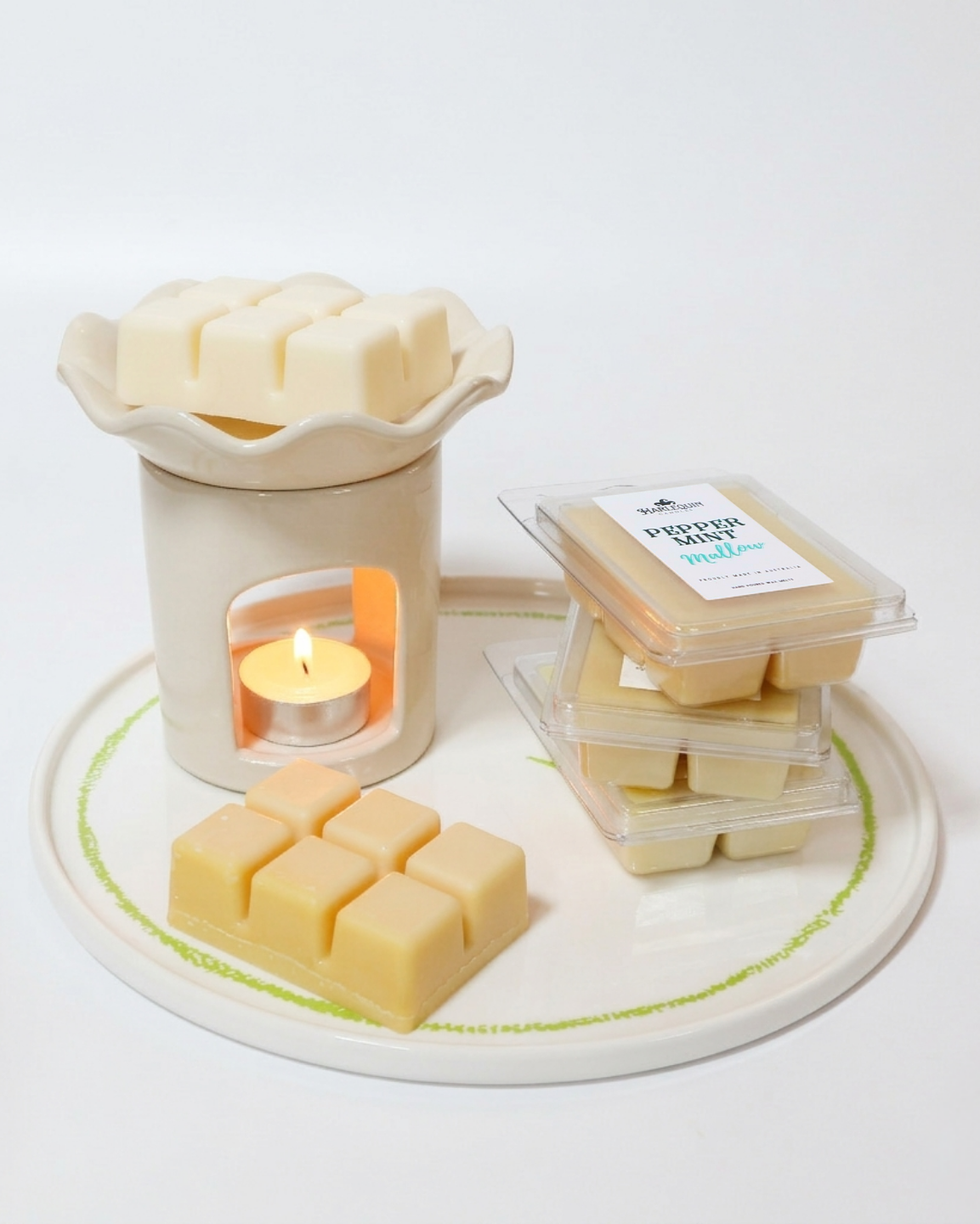 A close-up of a white wax melt warmer melting a natural soy wax cube next to a package of "Peppermint Mallow" melts. Handmade, high-scent load Australian wax melts.