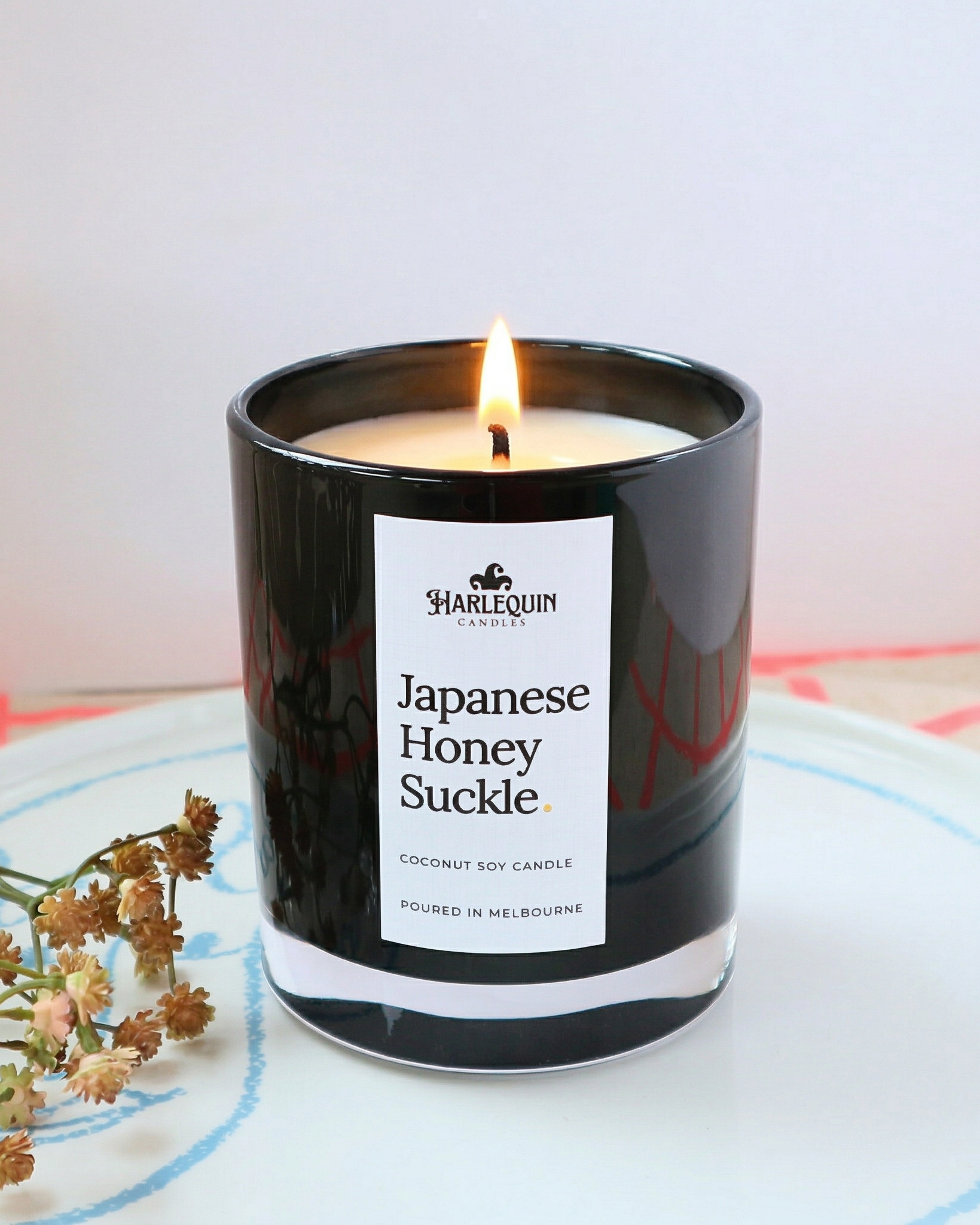 Harlequin Candles Japanese Honeysuckle fragrance in a luxury black glass jar, handcrafted in Melbourne, Australia.