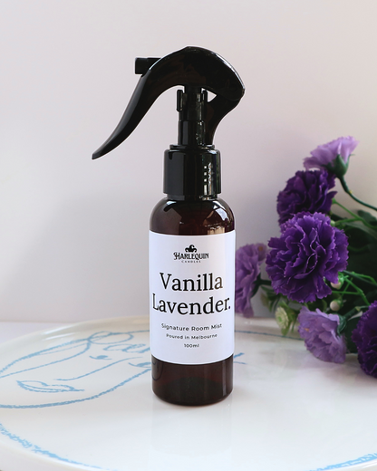 Luxury Vanilla Lavender home fragrance spray styled with purple carnations on a white designer tray, relaxing aromatherapy mist and linen spray by Harlequin Candles.