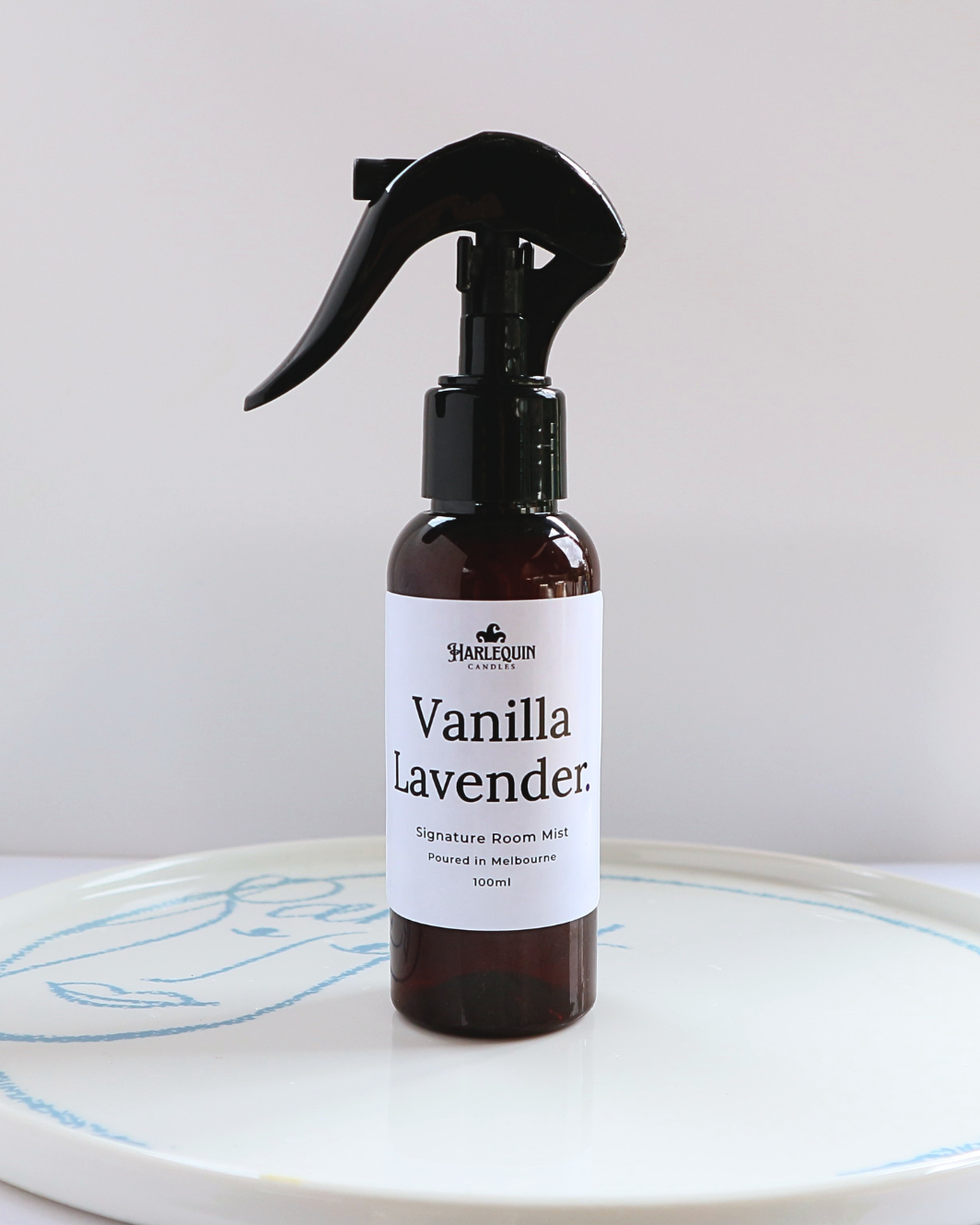 Harlequin Candles Vanilla Lavender 100ml signature room mist in a premium amber spray bottle on a minimalist white ceramic tray, hand-poured in Melbourne Australia.