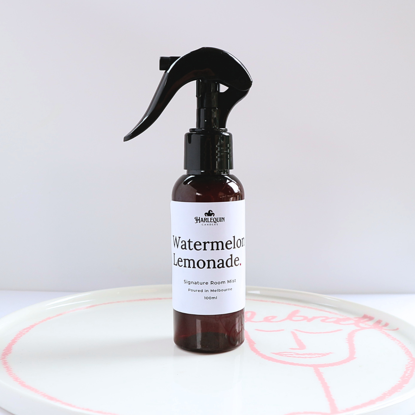 Harlequin Candles Watermelon Lemonade 100ml signature room mist in an amber spray bottle on a minimalist white ceramic tray, hand-poured in Melbourne Australia.